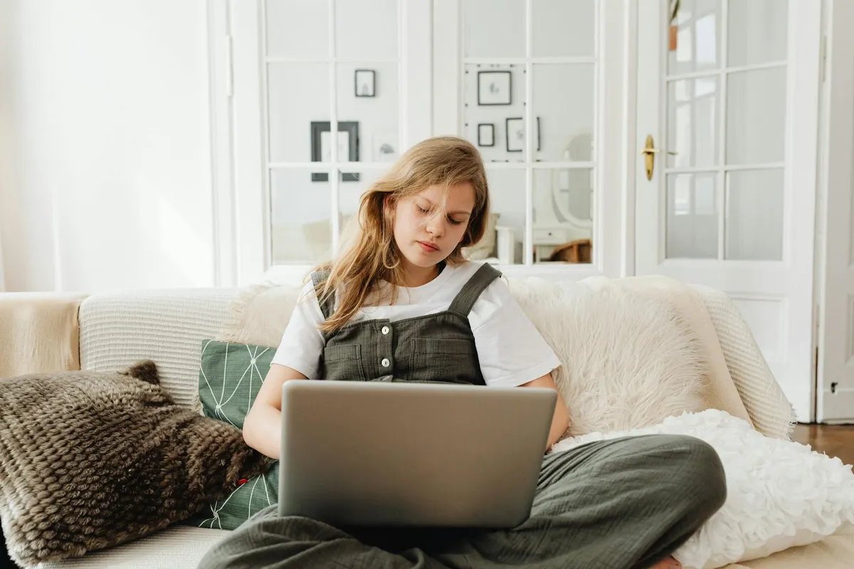 A person at a laptop in soft natural light, working calmly